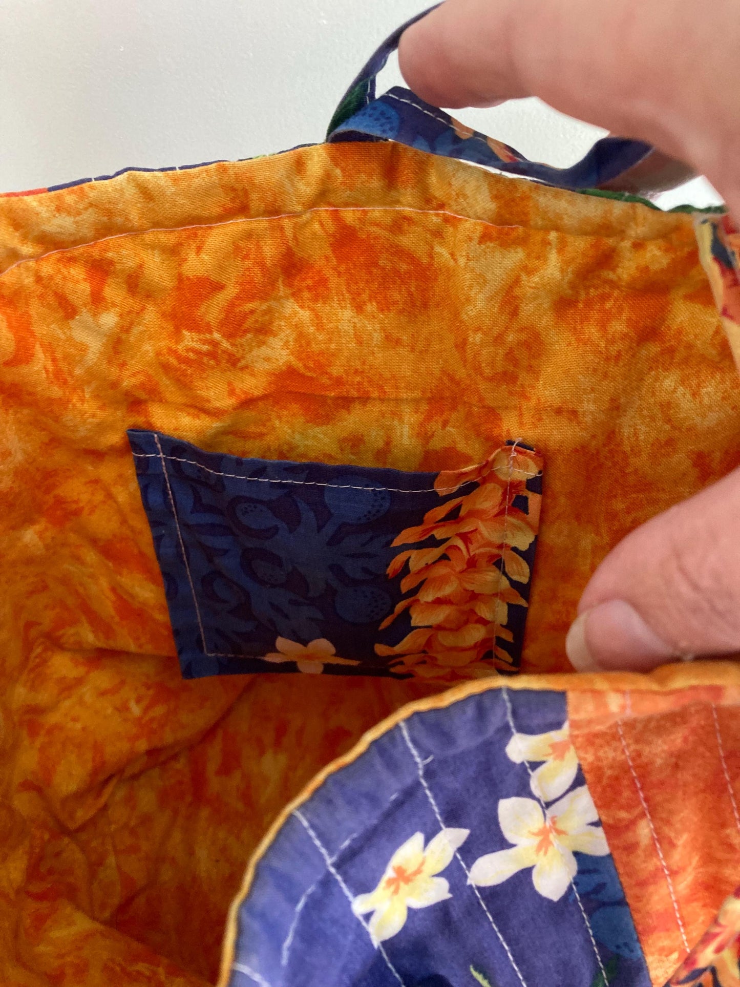 Close-up of a hand holding an orange and blue interior pocket fabric tote bag - Australian Made