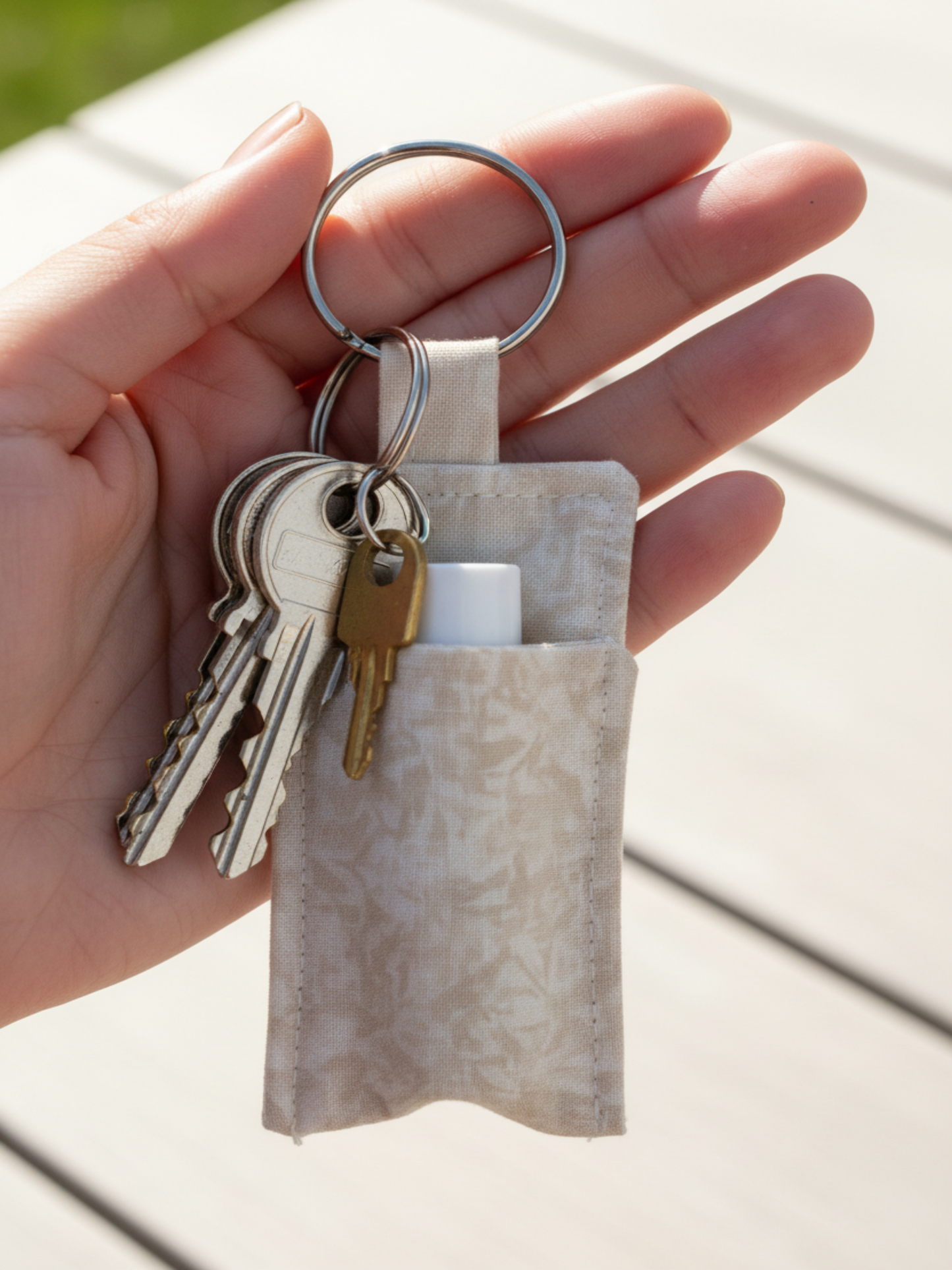 Beige keyring lip balm holder with keys attached