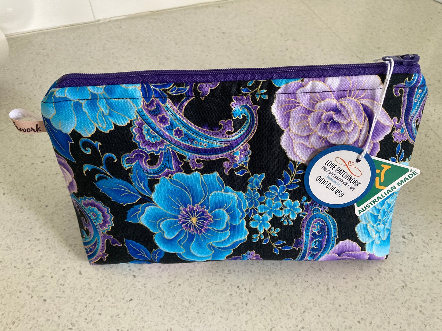 Australian Made Floral patterned pouch with a visible Love Patchwork brand tag and on a light surface