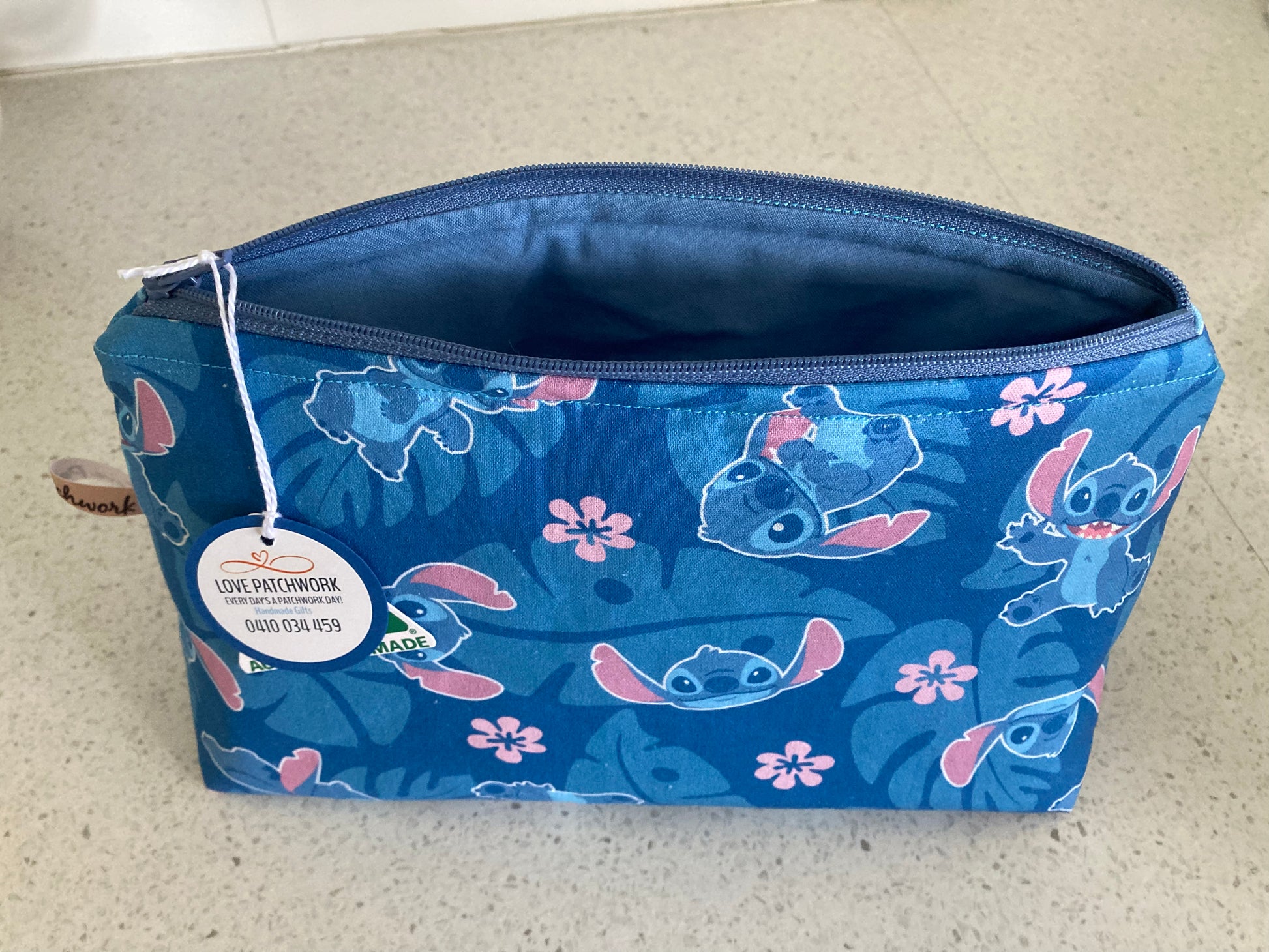 Opened Lilo & Stitch zipper pouch showing size and interior detail - Australian Made by Love Patchwork Disney zipper pouch on grey surface