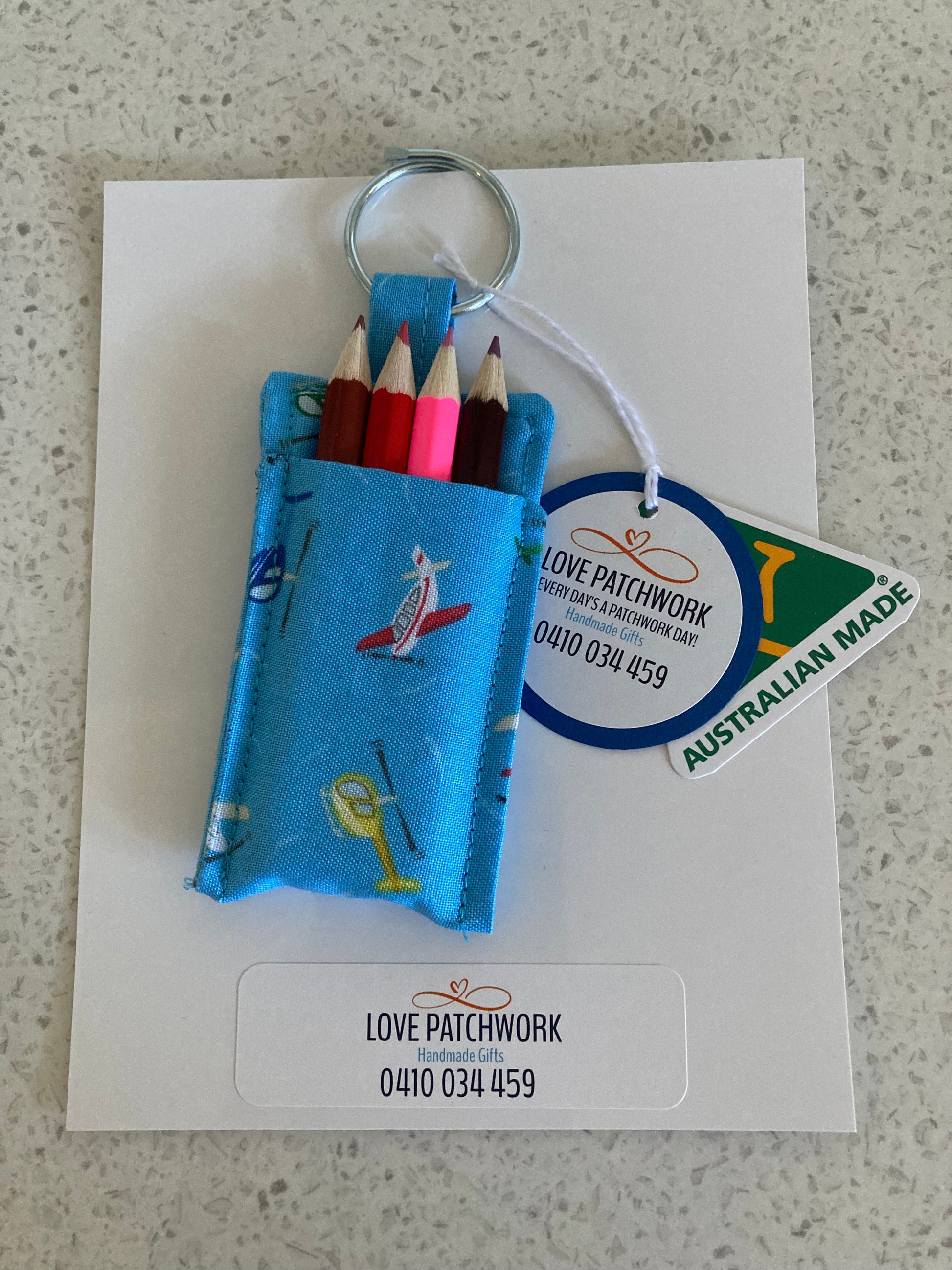 Novelty aviation keychain with colourful pencils holder on a card featuring 'Love Patchwork' branding. Australian Made