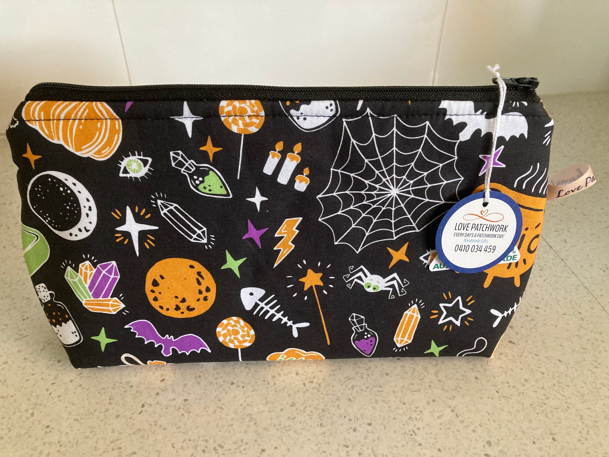 Black zippered pouch with Halloween-themed designs on a light surface, Handmade by Love Patchwork, Australian Made