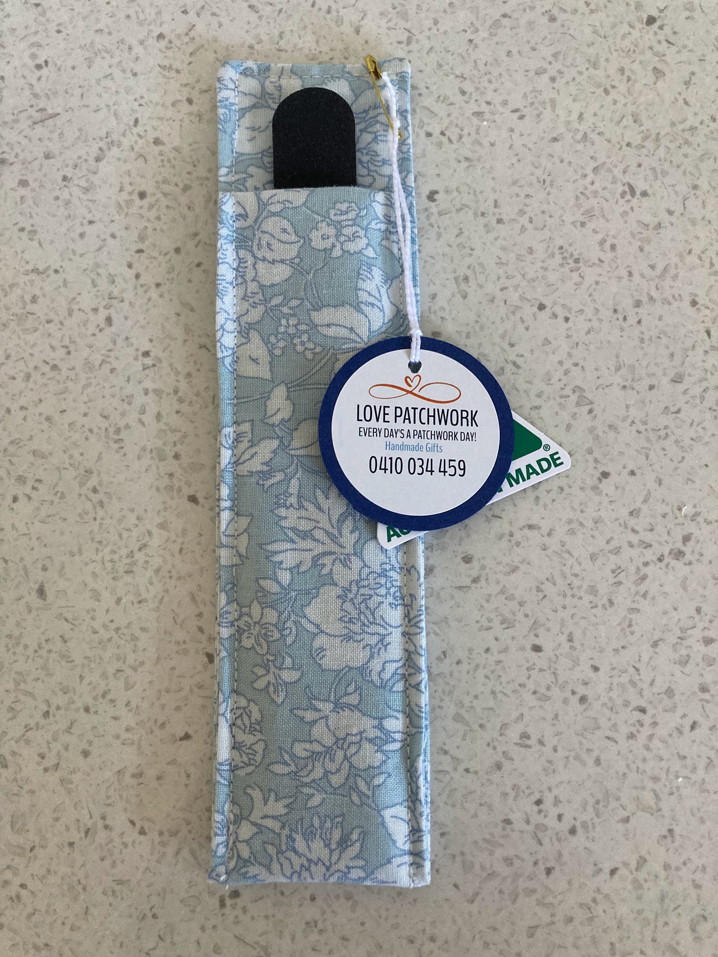 Nail file holder product with a visible brand label on a beige surface