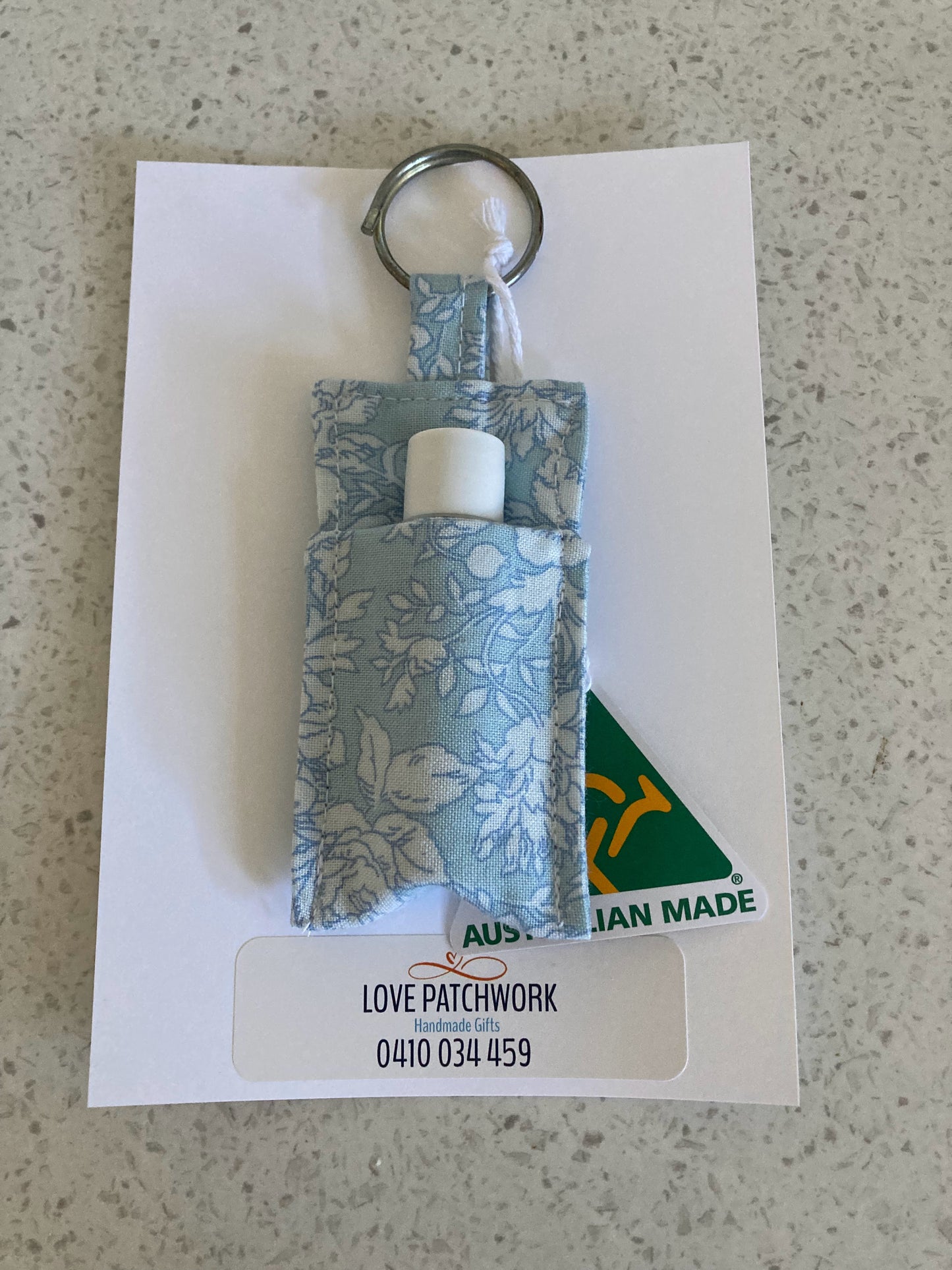 Lip Balm keychain with floral design on a white card, featuring 'Love Patchwork' branding.